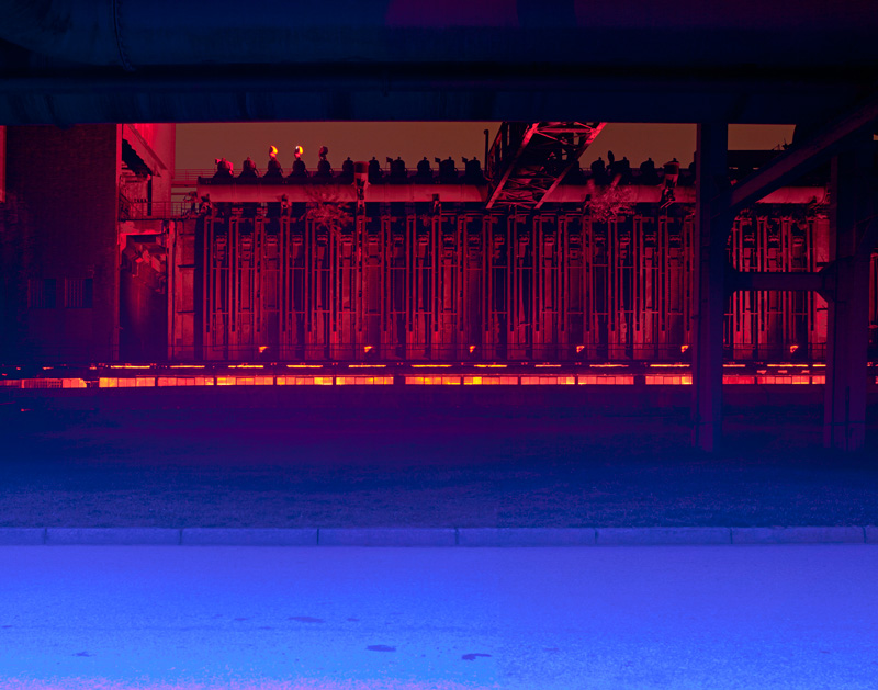 Der Weg an der Ofenseite der Kokerei wird nachts blau beleuchtet